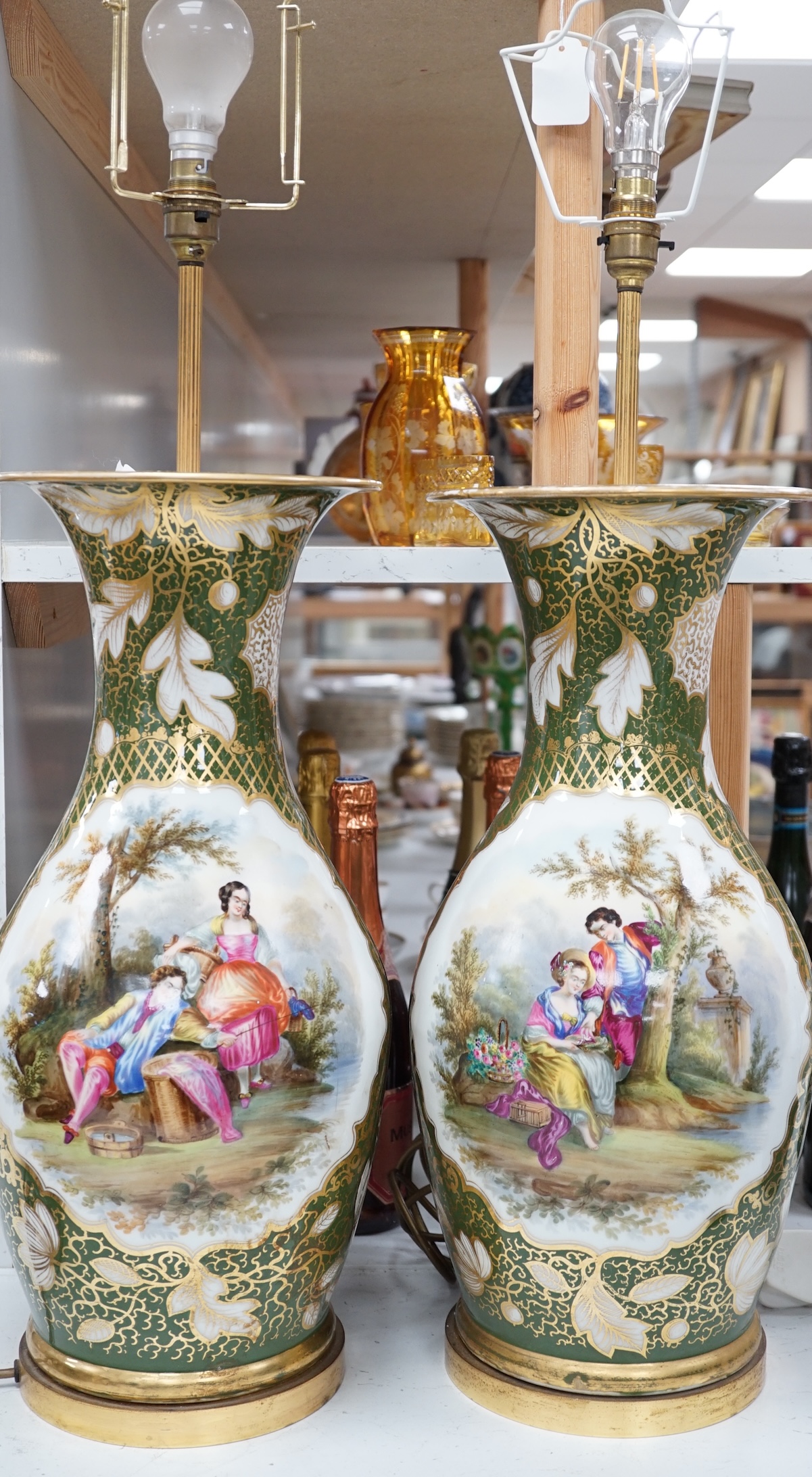 A large pair of Continental porcelain vases converted to lamps, painted with figures before landscapes, 51cm high excluding the fitting. Condition - fair to good. Untested.